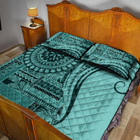 Turquoise quilt bed set featuring circular motif, teal geometric bands, and two square pillows