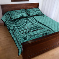 Turquoise quilt bed set with ornate geometric artwork, wavy quilting texture, and two pillows