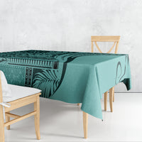 Turquoise tablecloth with bold tribal and leaf patterns, draped over a dining table