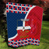 Personalized quilt on grass showing Dominican flag, 180th years text, and blue-red plaid