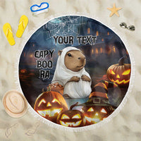 Round black Halloween beach blanket: capybara ghost, pumpkins, fringe, 'YOUR TEXT'.