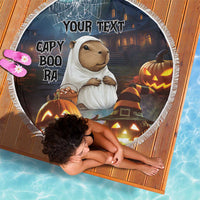 Round black Halloween beach blanket with capybara ghost and jack-o'-lantern pumpkins, 'YOUR TEXT'.