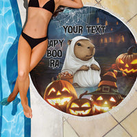 Round black Halloween beach blanket with capybara ghost artwork, pumpkins, 'YOUR TEXT', fringed edge.