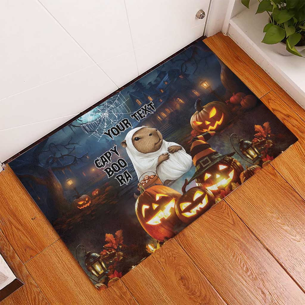 Halloween rubber doormat angled on floor, capybara ghost, glowing pumpkins and 'YOUR TEXT'.