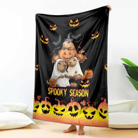 Spooky season blanket draped on the floor, black with orange glow and jack-o’-lantern graphics