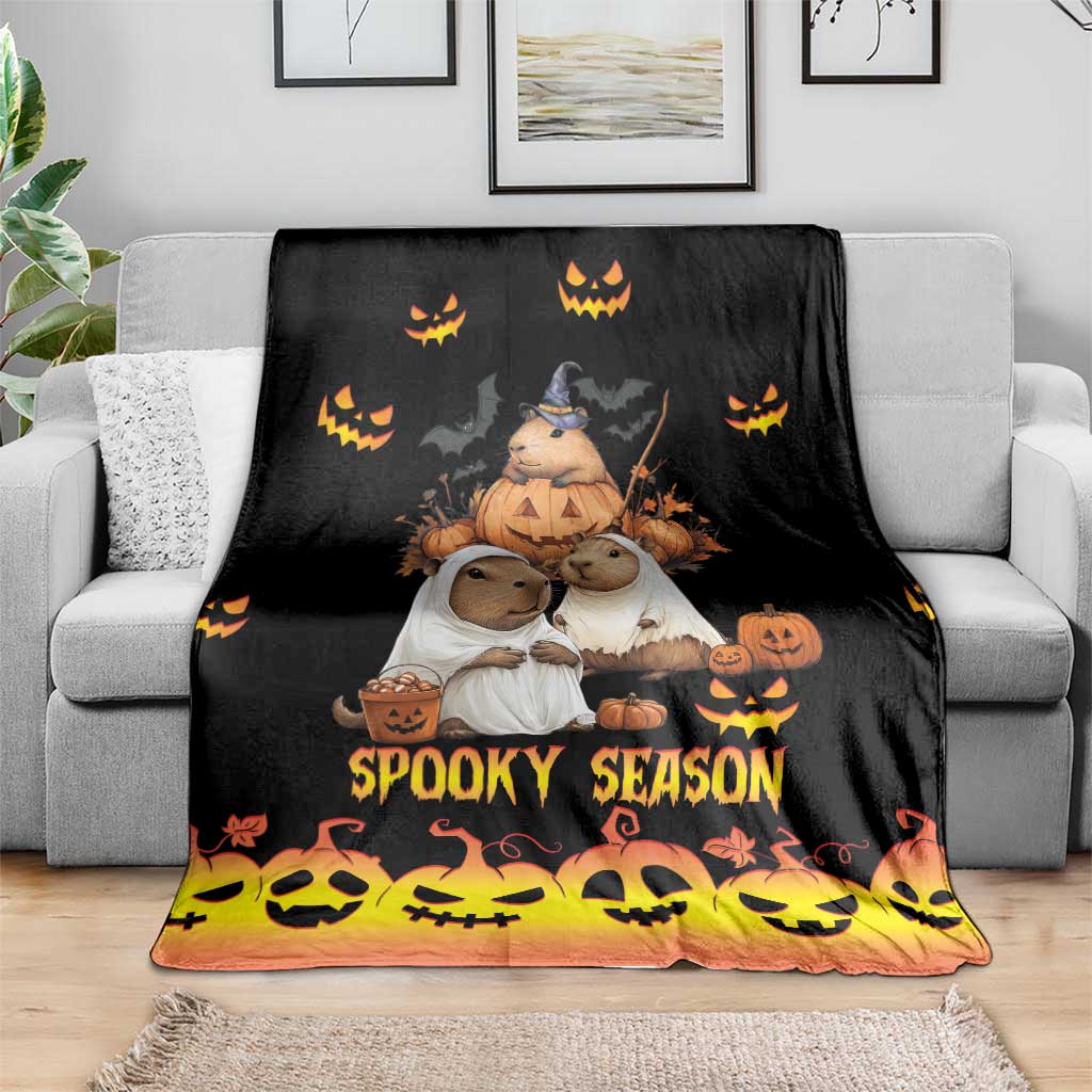 Spooky season blanket on a sofa, black top with orange fade and “Spooky Season” text