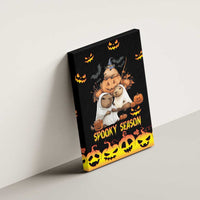 Black canvas wall art mounted against a wall, showing pumpkins, animals, and “Spooky Season”