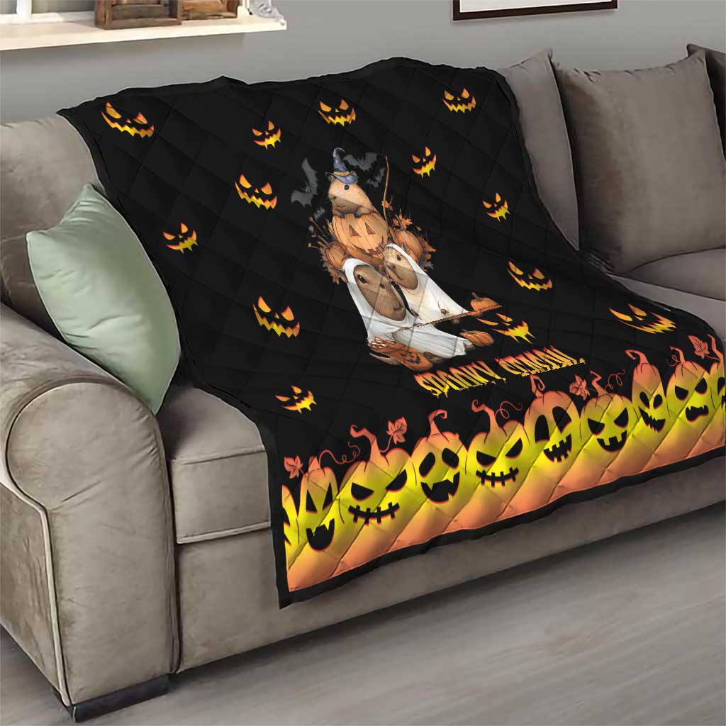 Black quilt on sofa with quilted pattern, orange jack-o-lantern icons, and 'Spooky Season' text