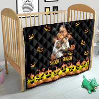 Black quilt on crib with jack-o-lantern icons, central Halloween bear scene, and 'Spooky Season'