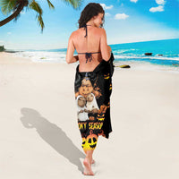 Black sarong tied at waist with spooky animal print and jack-o-lantern stripe hem