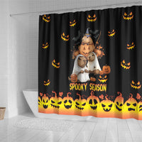Spooky season shower curtain with black background, orange pumpkin-face bottom border, animal characters