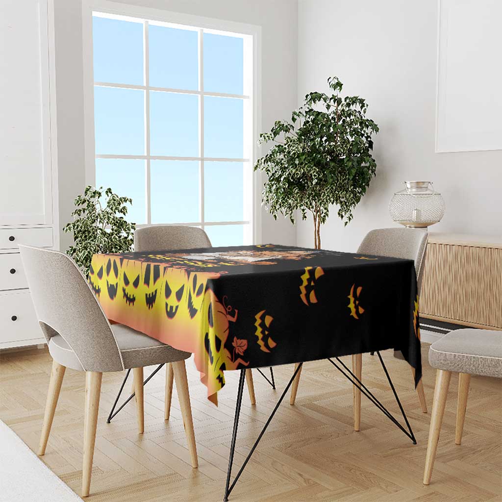 Halloween tablecloth, dark pumpkin-face print with orange gradient across dining table