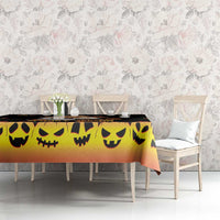 Halloween tablecloth, orange gradient with black jack-o’-lantern smile faces on table