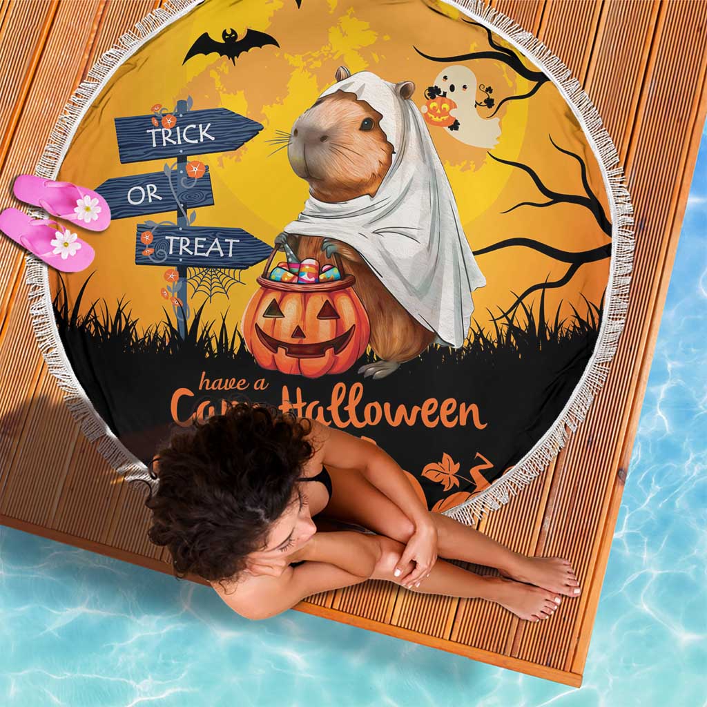Round orange beach blanket with capybara ghost, trick-or-treat signs, and fringed edge