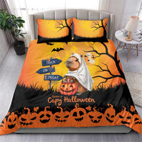 Orange Halloween bedding set on bed with two pillows; capybara ghost, trick-or-treat and pumpkins