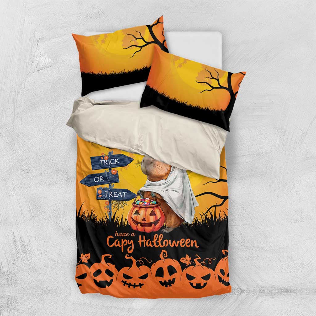 Orange Halloween bedding set flat lay with two pillows and fitted duvet; capybara ghost and pumpkins