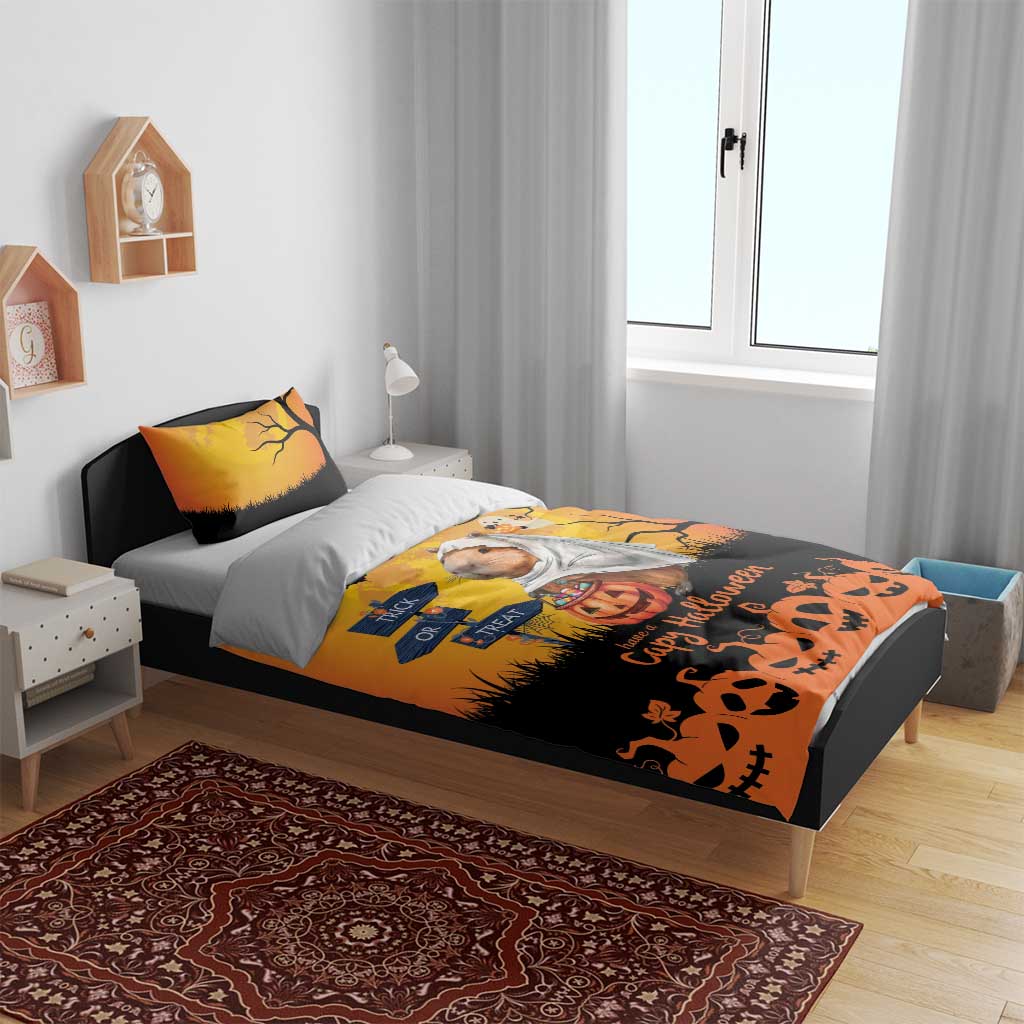 Orange Halloween bedding set on gray bed: capybara ghost print, bats, and pumpkin “Have a Capy Halloween”