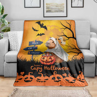 Orange and black capybara ghost Halloween blanket on couch with pumpkins, bats, and jack-o-lanterns