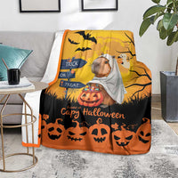 Orange capybara ghost Halloween blanket on floor with pumpkins, bats, and jack-o-lantern pattern
