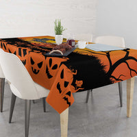 Orange Halloween tablecloth draped over dining table with jack-o-lantern pattern