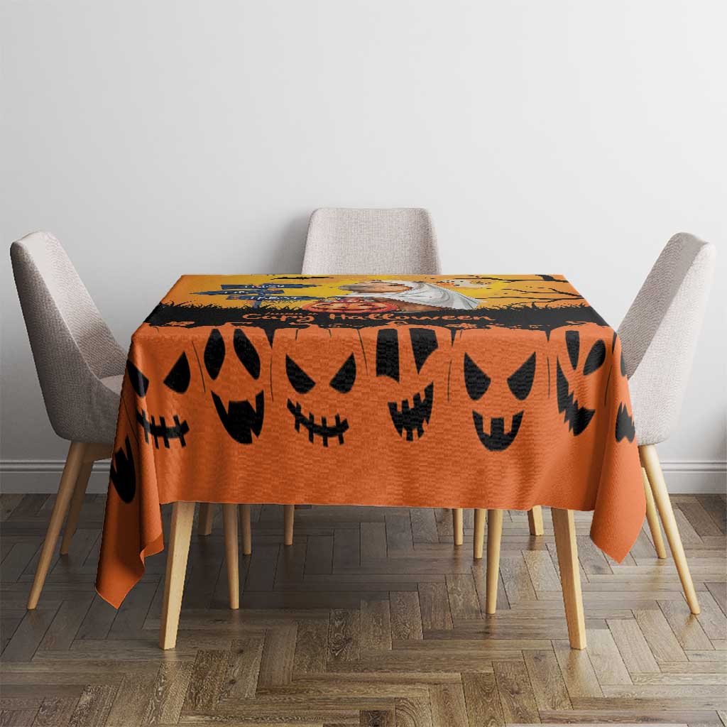Orange Halloween tablecloth with black jack-o-lantern faces on dining table