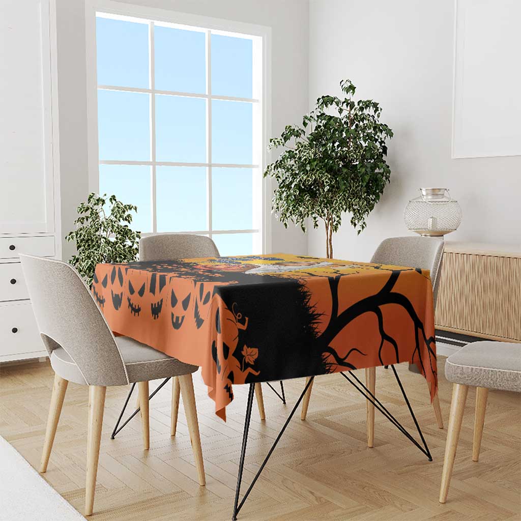 Orange Halloween tablecloth with black Halloween silhouettes and jack-o-lantern faces