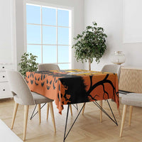 Orange Halloween tablecloth with black Halloween silhouettes and jack-o-lantern faces