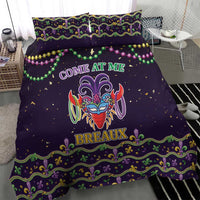 Purple duvet cover with two pillows, colorful carnival mask graphic and ornate green-gold border