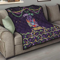 Black quilt on a living room sofa, with fleur-de-lis mask and green-purple ruffle border