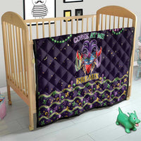 Black quilt in a baby bed, featuring Mardi Gras mask, bead strand, and “Breaux”