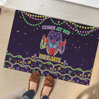 Black rubber Mardi Gras doormat with colorful bead strands, mask graphic, “COME AT ME”