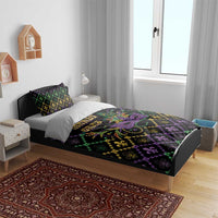 Geometric Mardi Gras bedding set on bed with purple mask, green jewels, and gold fleur-de-lis