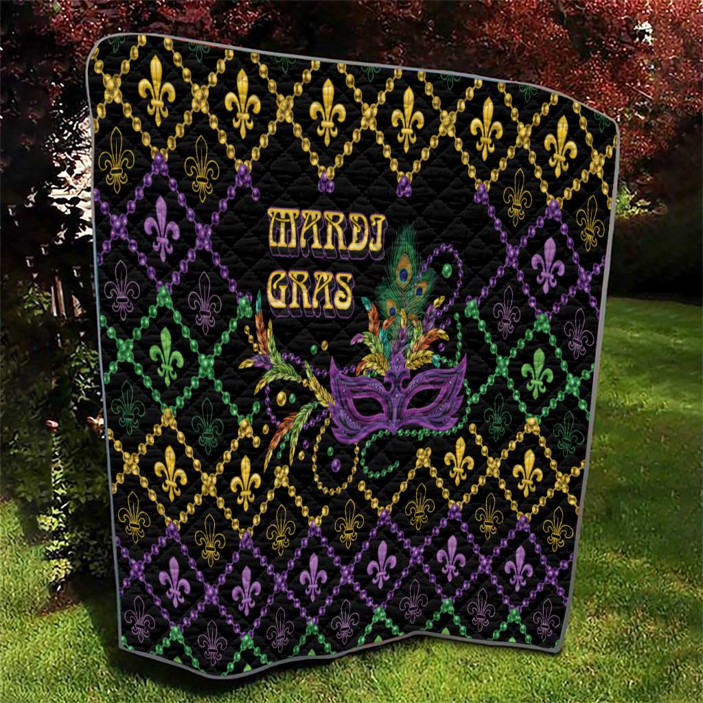 Mardi Gras quilt on grass, black geometric diamonds with fleur-de-lis and mask