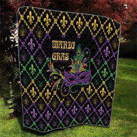 Mardi Gras quilt on grass, black geometric diamonds with fleur-de-lis and mask