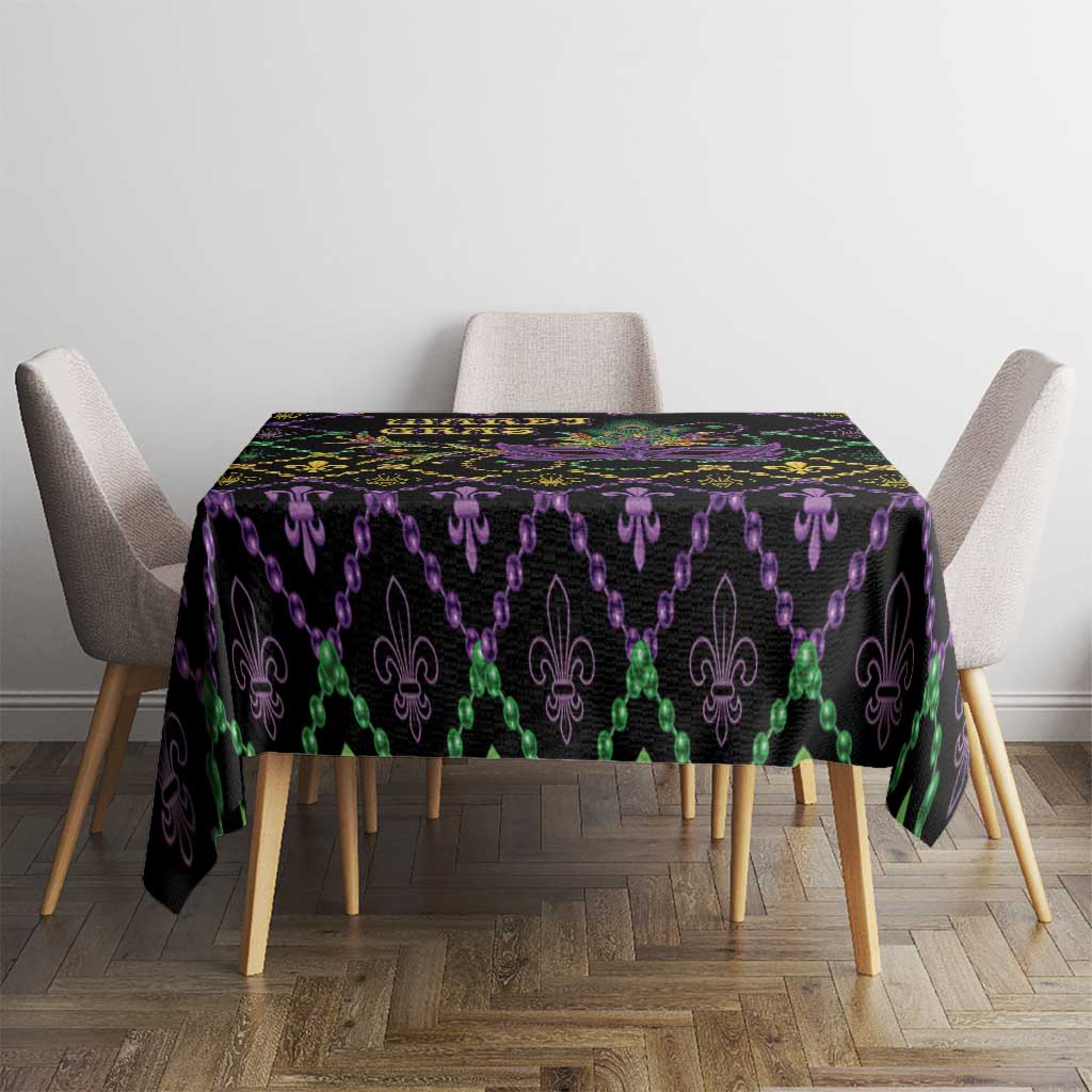 Rectangular black Mardi Gras tablecloth featuring purple and green fleur-de-lis icons with gold dots