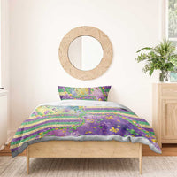 Purple duvet and pillowcases with fleur-de-lis glitter bead details and gold-green stripes, front view
