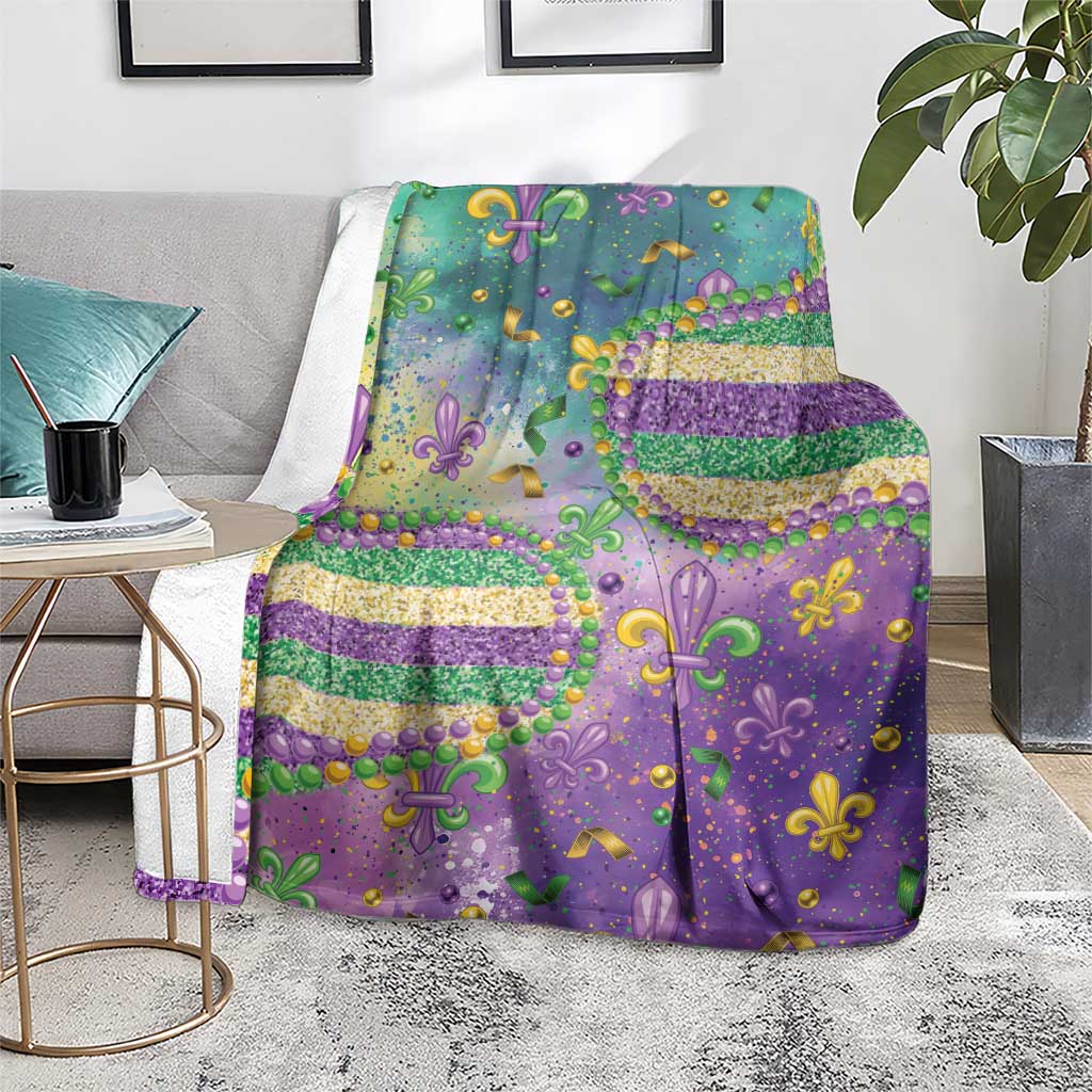 Purple Mardi Gras blanket with teal fleur-de-lis motifs, glitter beads, and gold confetti details