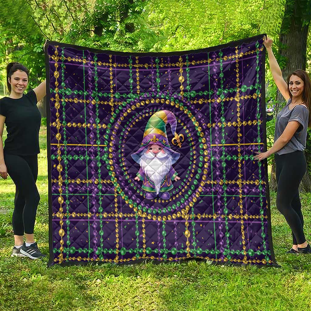 Purple quilt spread out with gnome artwork in center, gold and green bead trim