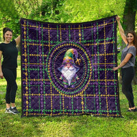 Purple quilt spread out with gnome artwork in center, gold and green bead trim