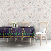 Mardi Gras tablecloth on long table, purple and green bead garlands with gold trim