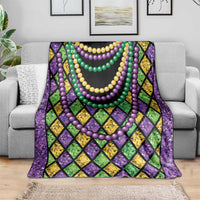Beads-themed blanket on gray couch, purple diamonds with layered yellow, green, and purple bead garlands