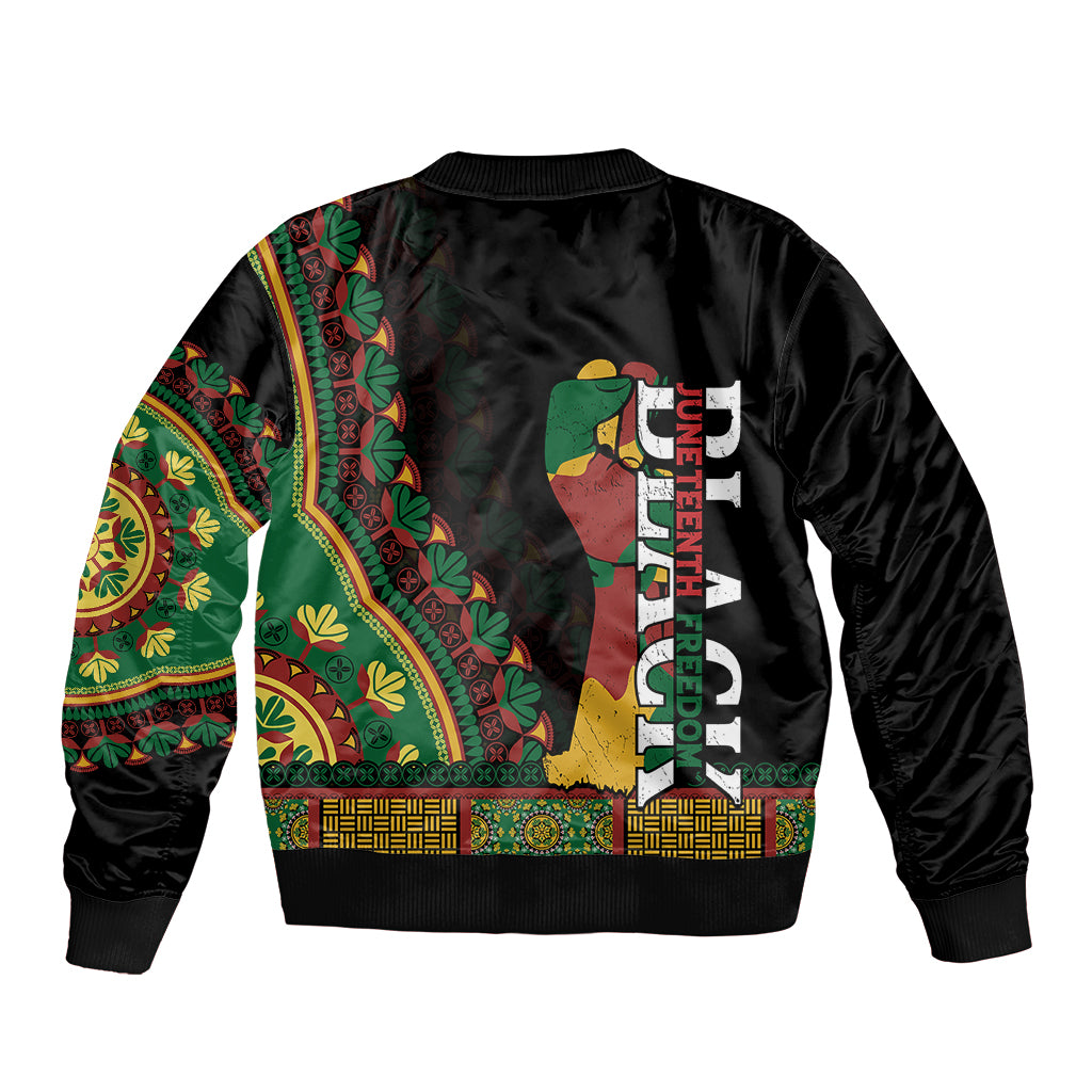 Black bomber jacket back; green and brown patterned sleeves with central figure and vertical text