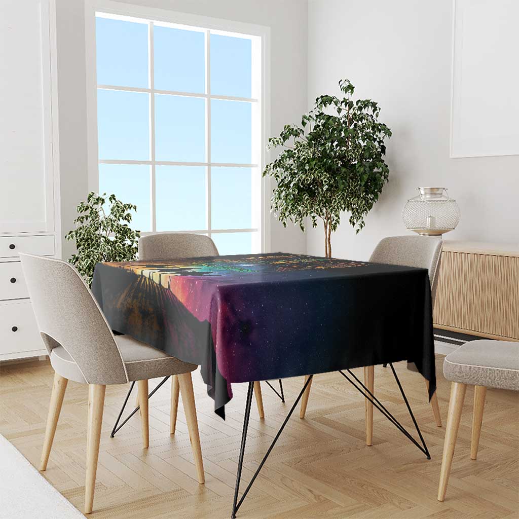 Black tablecloth with colorful starry road design draped over dining table