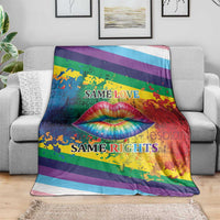 Rainbow lips kiss blanket draped on sofa, rainbow stripes with lips graphic and “Same Love / Same Rights”.