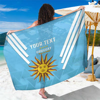 Light blue custom Uruguay sarong with white diagonal stripes, sun emblem, and YOUR TEXT