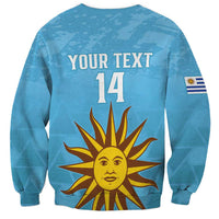 Unisex light-blue Uruguay football sweatshirt back with YOUR TEXT 14 and sun graphic