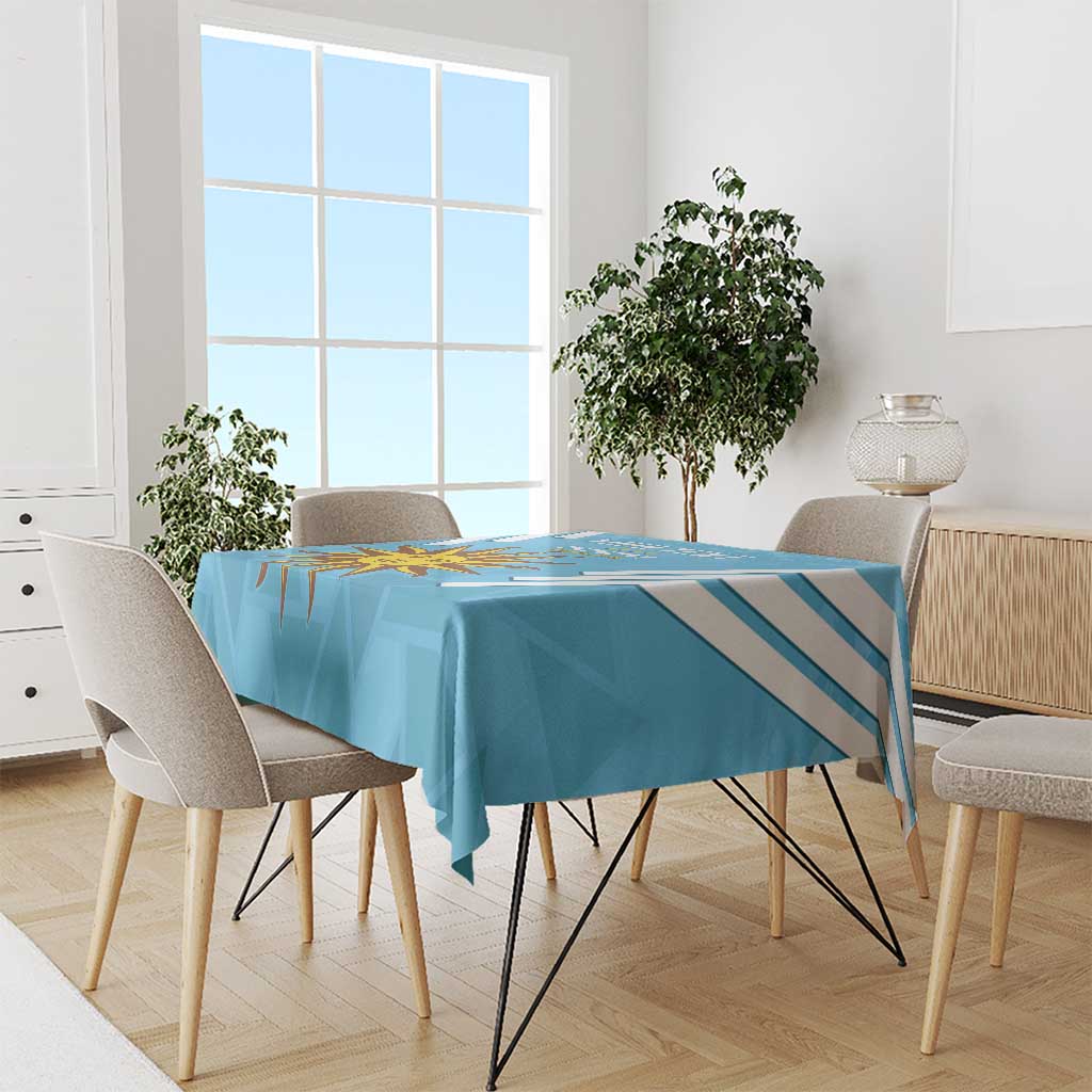 Blue Uruguay-themed tablecloth with diagonal stripes and sun emblem on a square table