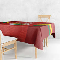 Red football tablecloth draped over a wooden table, with multicolor diagonal stripe edges
