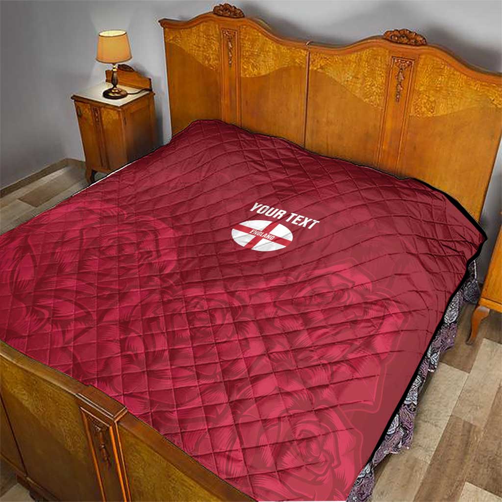 Red quilt with diamond stitching and custom text over England crest emblem on bed