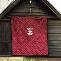 Red quilt with diamond stitching and custom text over England crest emblem hanging on wall